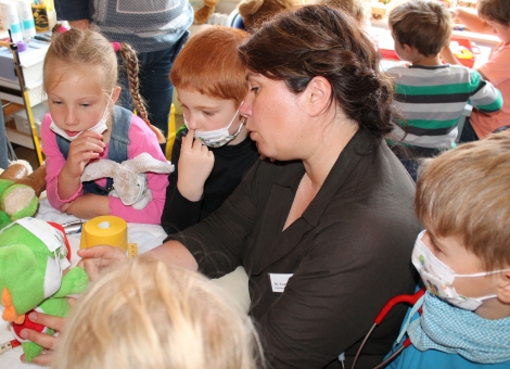 Miriam Krasmann, Assistenzärztin in der Pädiatrie des Marien Hospital Papenburg Aschendorf, erklärt den faszinierten Kindern anhand eines Plüschdrachens ganz geduldig, welche Unter-suchung als erstes vorgenommen wird.