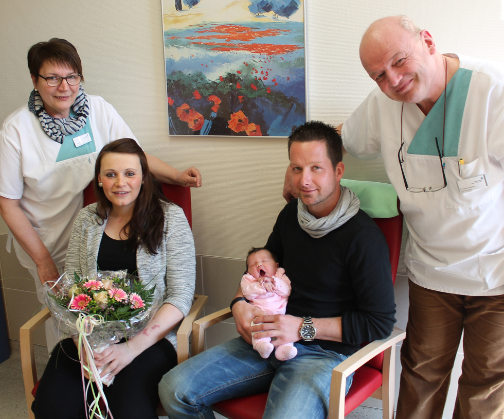 Chefarzt Dr. Franz Koettnitz (rechts) und die Leitende Hebamme Hella Siemer (links) gratulieren den Eltern Anja Robben und Daniel Book zur Geburt ihrer Tochter Fiona, dem 100. Baby in diesem Jahr im Marien Hospital.