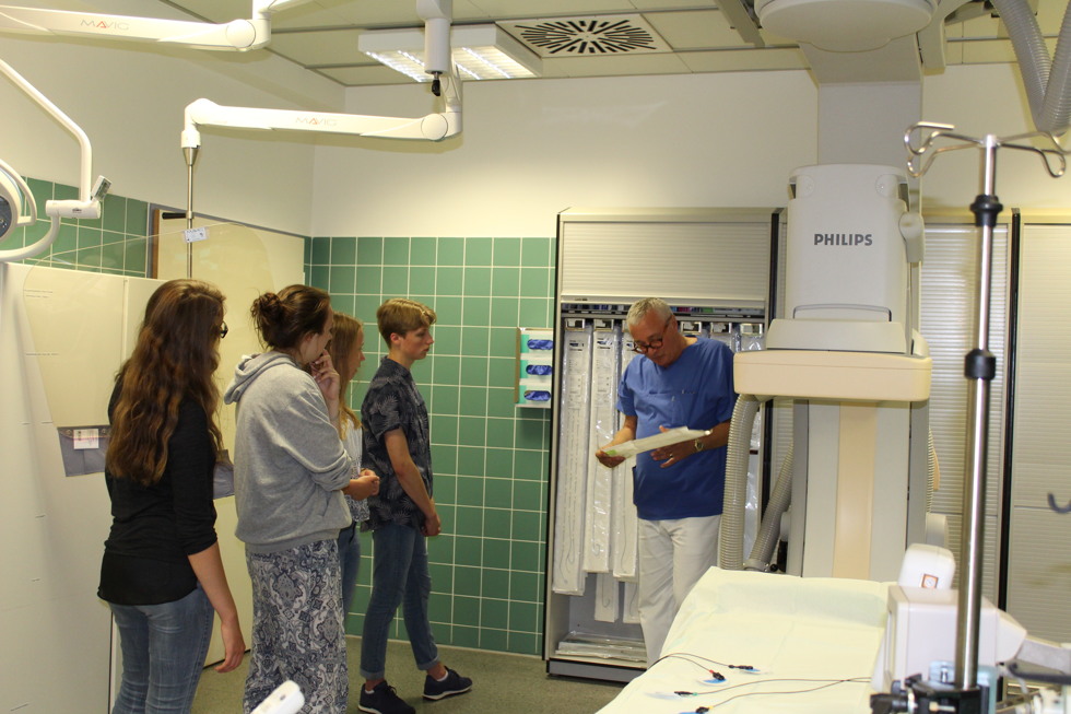 Besichtigung des Herzkatheterlabors: Chefarzt der Kardiologie, Prof. Dr. Christian Wende (rechts), mit Teilnehmern der Schüler-Akademie bei der kardiologischen Röntgenanlage.